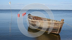Small wooden boat floating on the clear water