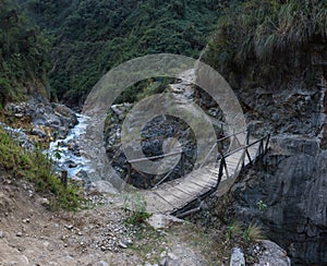 Small wooden bridge crossing a river along the Salkantay Trail