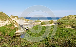 A small wooden bridge over a narrow stream at the entrance to Sola beach