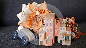 Small wooden car with origami, houses and Biedermeier bouquet