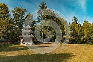 Small wooden chapel rural building edge of forest scenic environment meadow and golden trees foliage view in August summer time