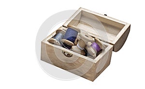 Small wooden chest with old sewing threads on spools