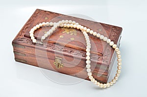 Small wooden chest with white pearl necklace
