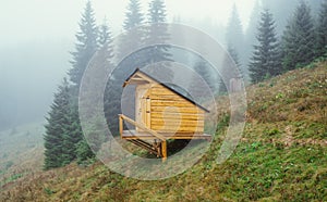 Small wooden country house in the mountains in foggy weather