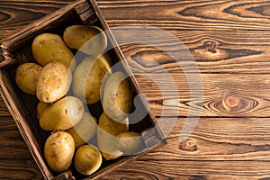 Small wooden crate filled with fresh potatoes
