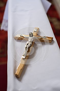 a small wooden cross with Jesus Christ placed on a kneeler before the wedding