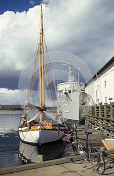 Small wooden cutter and an old warship