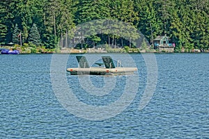 Small wooden dock floats on the calm waters of New Hampshire's Lake Winnipesaukee