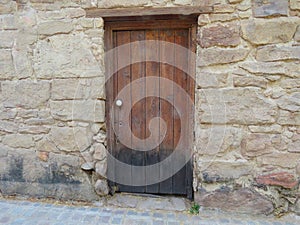 Small wooden door of an old house. historical stone architecture