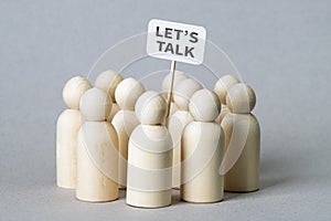 Small wooden figures with a `Let`s Talk` poster photo