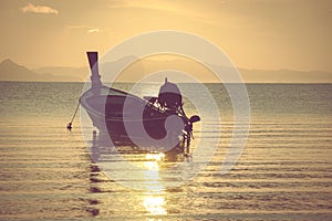 Small wooden fishing boat moored at the beach in the morning