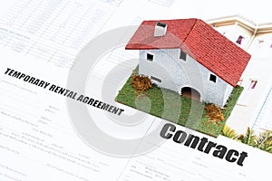 Small wooden house on contract forms.