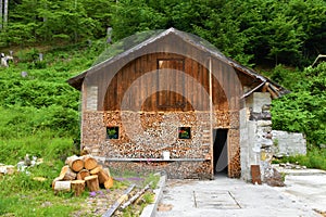 Small wooden house with firewood stacked in front