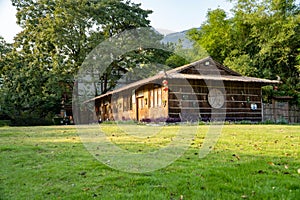 Small wooden house with lawn and green trees