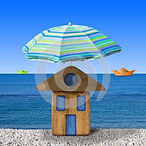 Small wooden house at seaside with umbrella beach - concept image