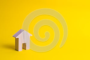 A small wooden house stands on a yellow background.