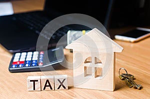 Small Wooden house and taxes on the desktop .. Taxes on real estate, payment. Penalty, arrears. Register of taxpayers for property