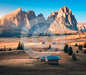 Small wooden houses in beautiful mountain valley at sunset