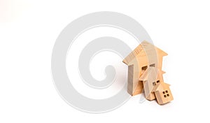 Small wooden houses fall on the big house as a domino. The concept of buying real estate. Insurance and investment risk. Falling p