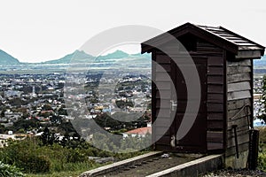 Small wooden hut on the edge of field, city in the background