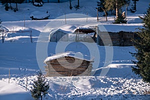 Small wooden hut at the foot of the snow-covered Tianshan Mountains in winter