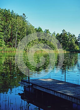 Small wooden jetty by the lake in the summer