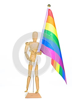 Small wooden mannequin holding a rainbow flag, isolated on white background