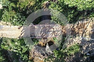 A small wooden old bridge is placed over a small stream in a village in Omkoi district, Chiangmai, Thailand. May 2021