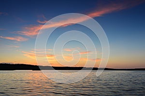 Small wooden pier on big lake at sunset