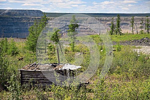 Small wooden shelter at the edge of open mine