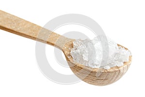 Small wooden spoon of coarse salt on white.