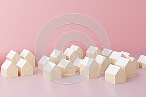 Small wooden toy houses on pink background. Real estate