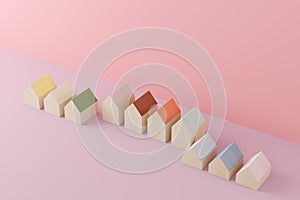 Small wooden toy houses on pink background. Real estate