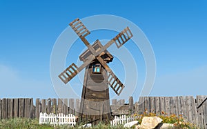 The small wooden windmill against the sky