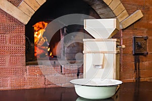 Small wooden windmill stands on the table next to the Russian stove