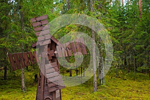 Small wooden windmill surrounded by pine forests