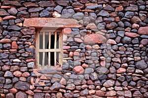 Small wooden window in an ancient stone wall