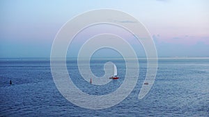 A small yacht sails in the Gulf of Finland during the white nights of St. Petersburg