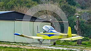 Small yellow airplane near its garage