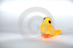 A small yellow chick. Plasticine bird on white background