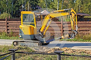 Small yellow crawler excavator for screwing piles
