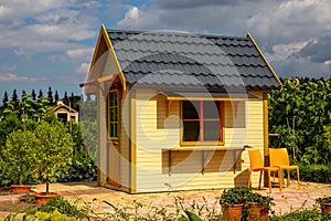 Small, yellow  garden house. Sunny day