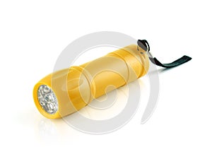 small yellow gold plastic cylinder flashlight with led light and black strap isolated on white background