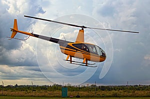 A small yellow helicopter takes off. Storm clouds in the background. A small private airfield in Zhytomyr, Ukraine