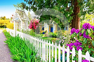 Small Yellow house exterior with White picket fence photo