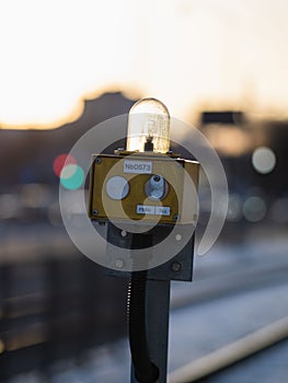 a small yellow machine stands on a train tracks, by the track