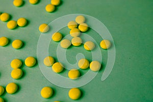Small yellow orange beautiful medical pharmaceptic round pills, vitamins, drugs, antibiotics on a blue background, texture.