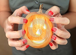 Small yellow pumpkin in hands