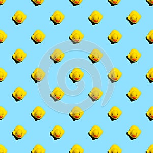 Small yellow rubber ducks on blue background seamless pattern; s