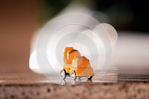 Small yellow toy car in the back with bokeh lights